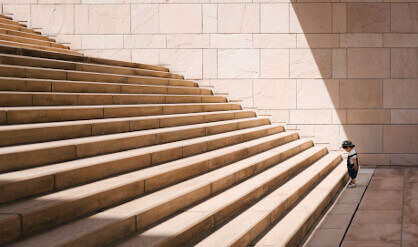 small child staring at a big staircase