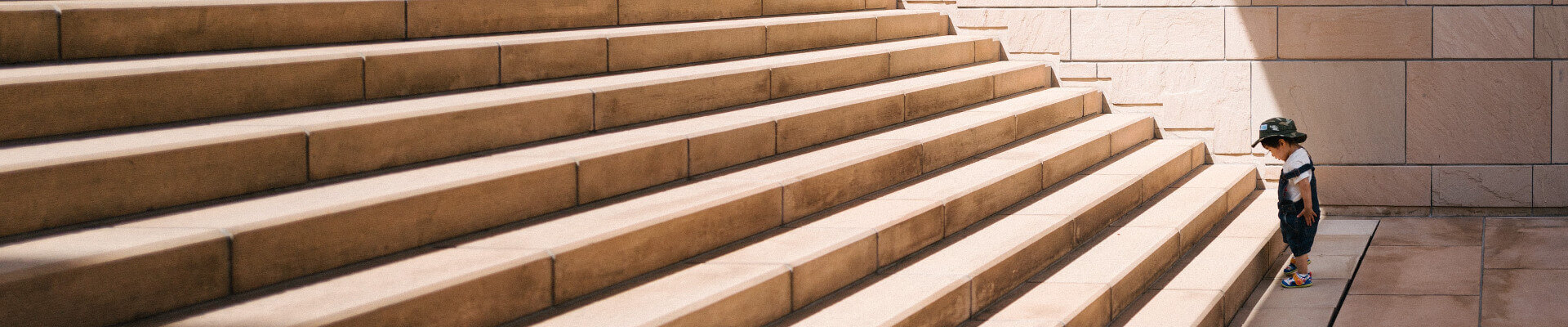 small child staring at a big staircase