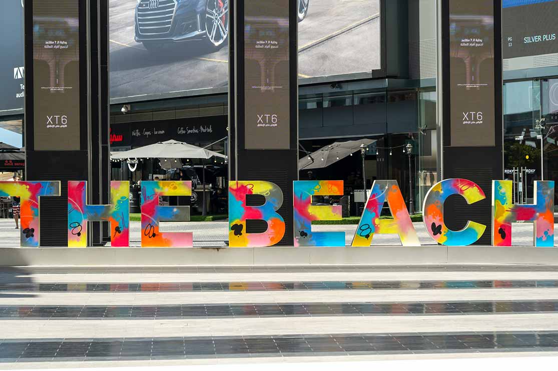 big "the beach" sign in front of stores