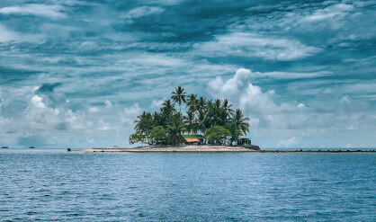 island in horizon surrounded by water