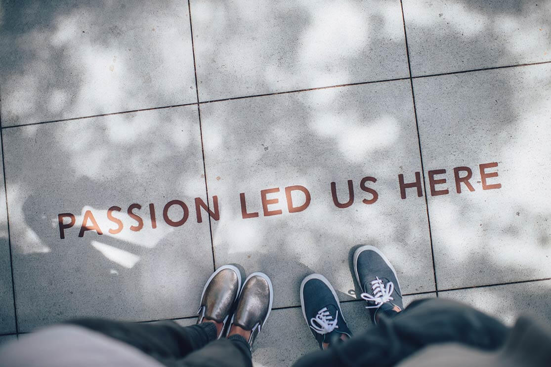 two people standing near text on pavement