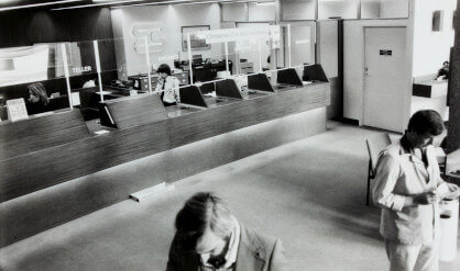 people in bank lobby black and white