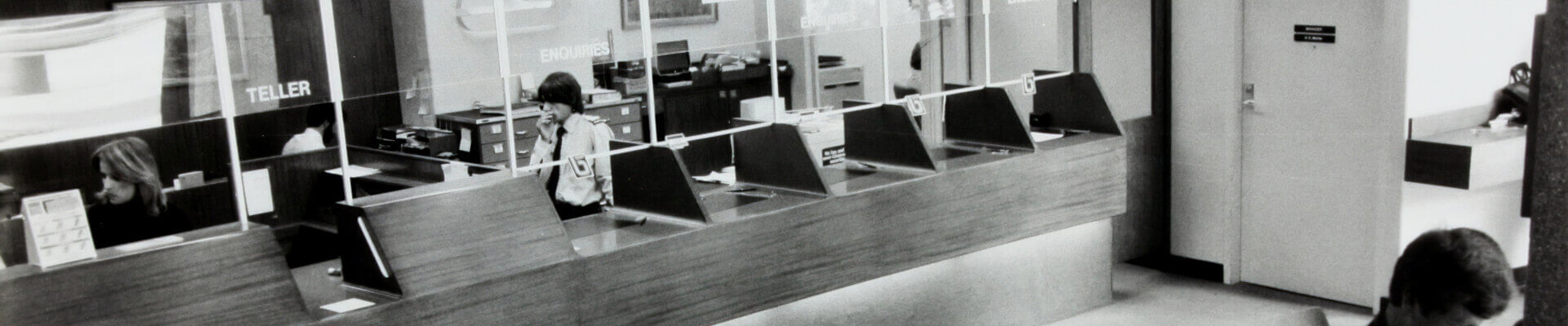 people in bank lobby black and white